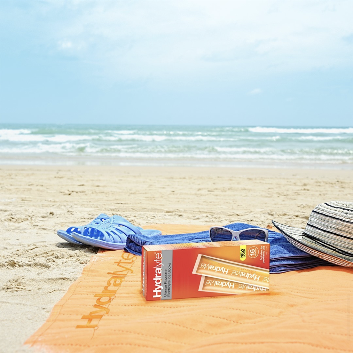 A box of Hydralyte iceblocks on a beach towel at the beach